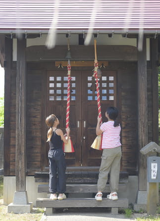 神社で拝む二人