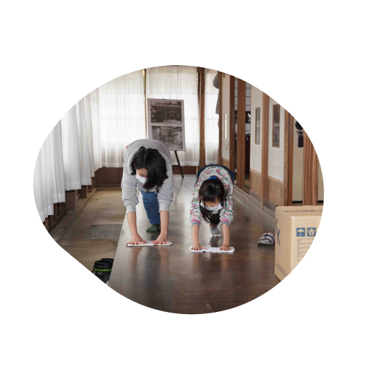 写真:主屋の廊下を掃除する親子