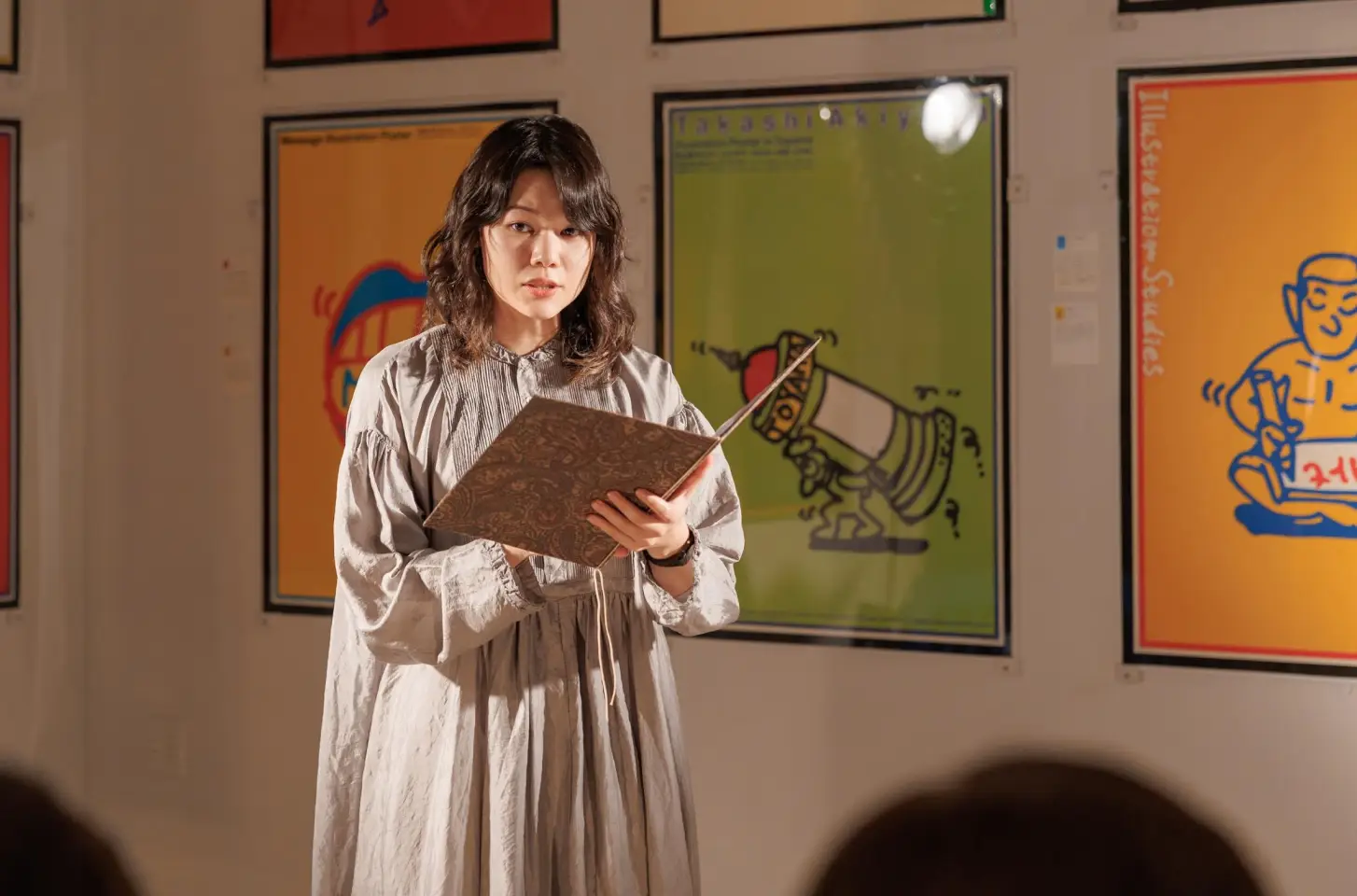 観客の前で朗読を行う亀山実里
